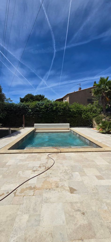 Piscine béton rectangulaire avec margelles en pierre naturelle et escalier d'angle, dans le Var